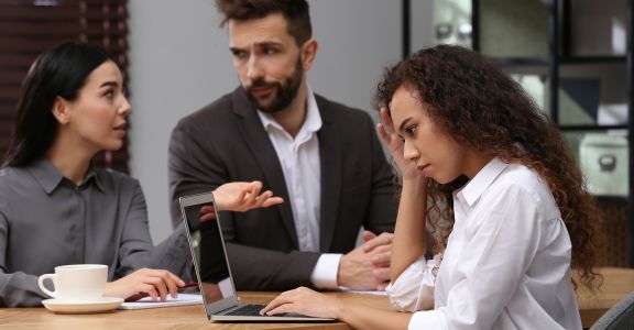 Woman at a meeting where co-workers are being hostile